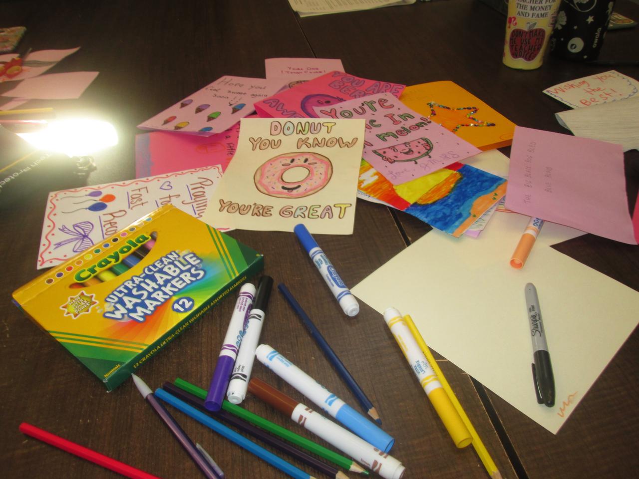 Handmade cards and drawing supplies on a classroom table